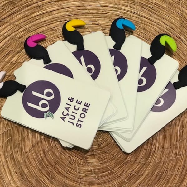 bb Acai & Juice Store gift cards with colorful toucan clips on a woven surface.