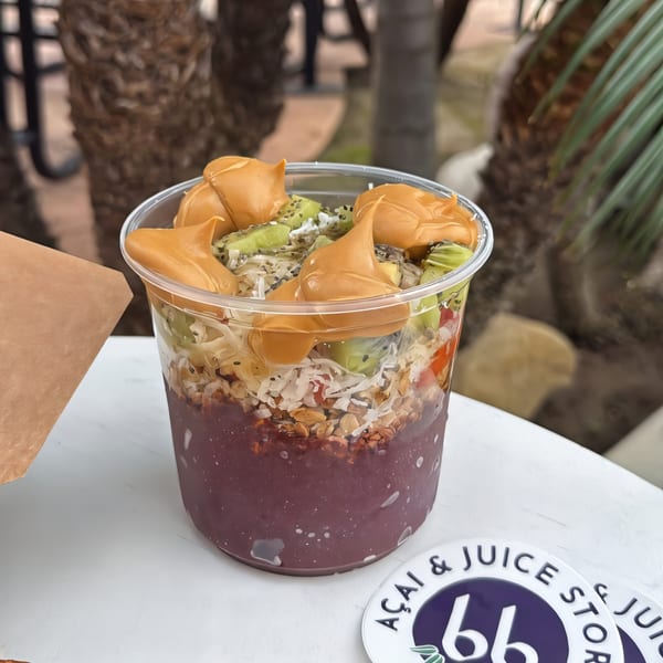 A bb Acai & Juice Store acai bowl with peanut butter, kiwi, granola, and coconut flakes.